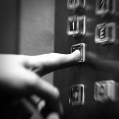 close-up of finger pressing elevator button