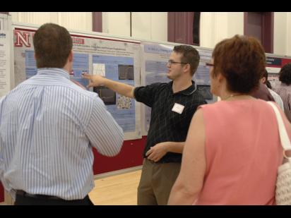 a student presenting his research poster
