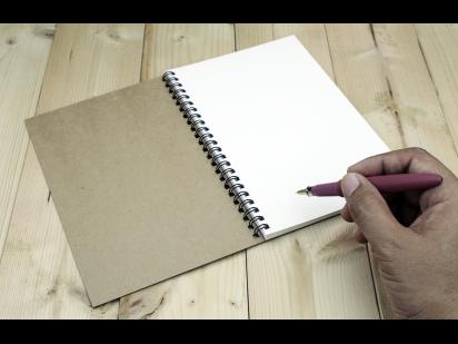 person writing in notebook