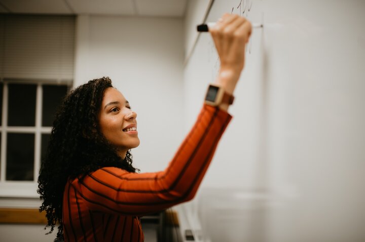 Person writing on whiteboard