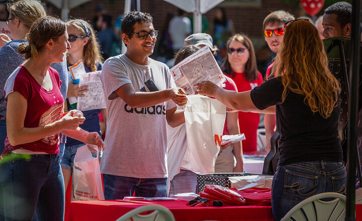 Graduate students visiting a vendor booth at the OGS Welcome Resource Fair Picnic
